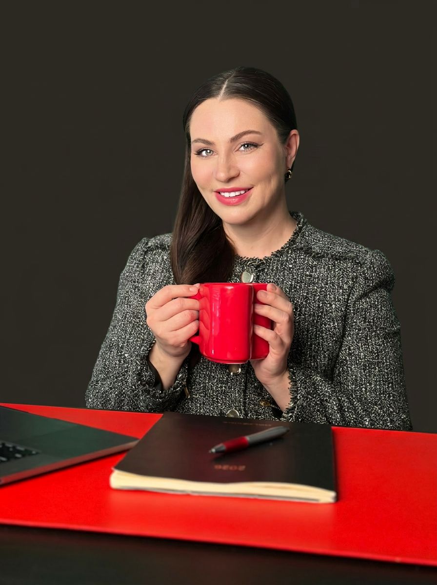 Luba in the Circle tea room, holding a red mug
