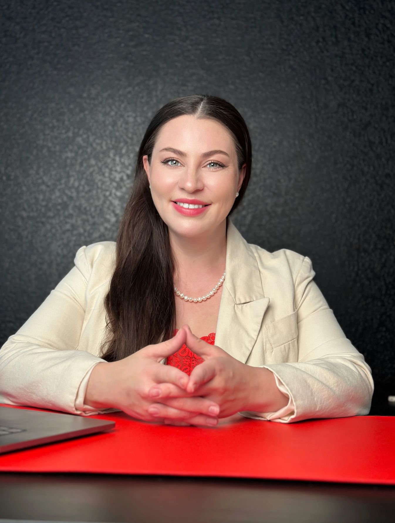 Luba Inz portrait — cream blazer, hands clasped